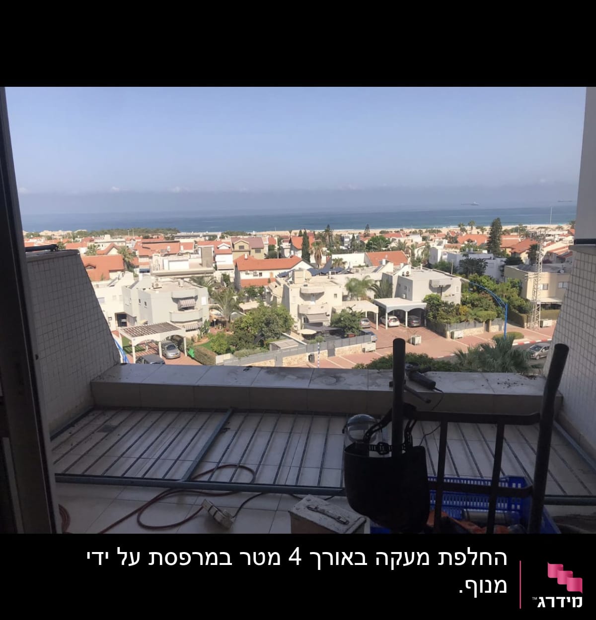 מסגרת חלון עם נוף לים ובתים